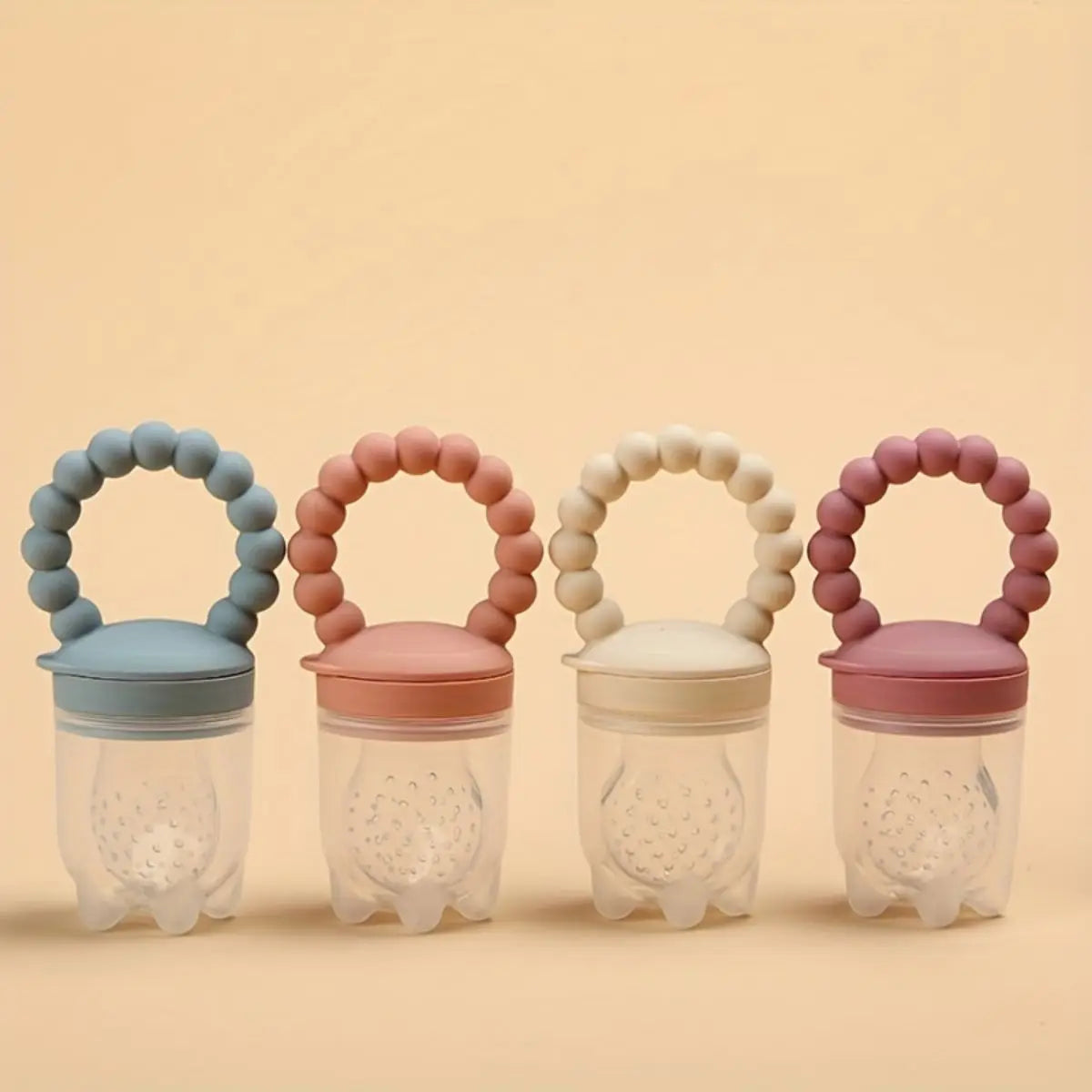 Four colorful silicone fruit feeder pacifiers with playful handles for teething babies.