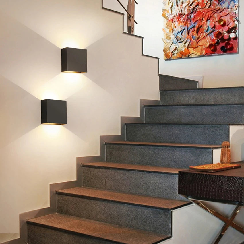 Modern Lampinbox decorative lamps illuminating a stylish staircase with art on the wall.