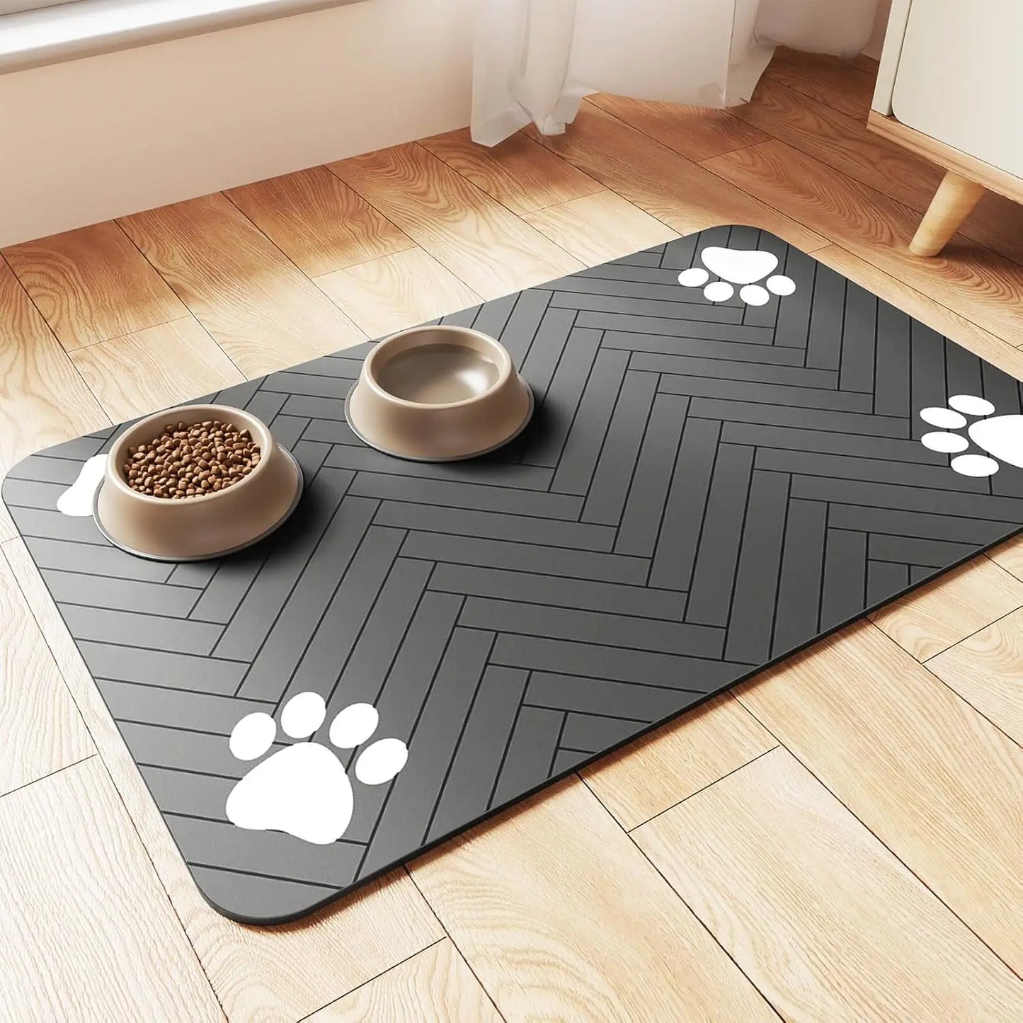 Waterproof pet feeding mat with paw prints, non-slip surface, and food bowls on wooden floor.