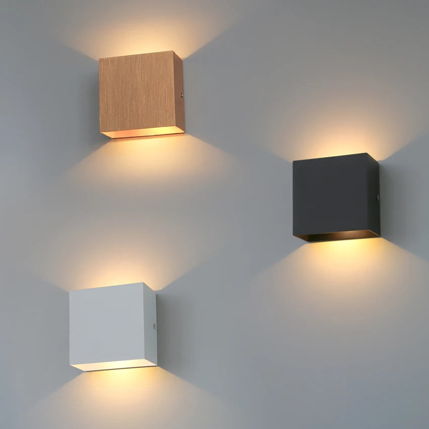Modern Lampinbox wall lamps in wood, black, and white showcasing sleek design and warm ambient lighting.