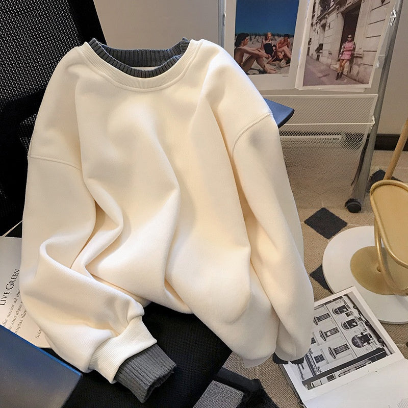 Chic spring outfit featuring a black layered sweater and a beige pleated skirt, perfect for seasonal fashion.